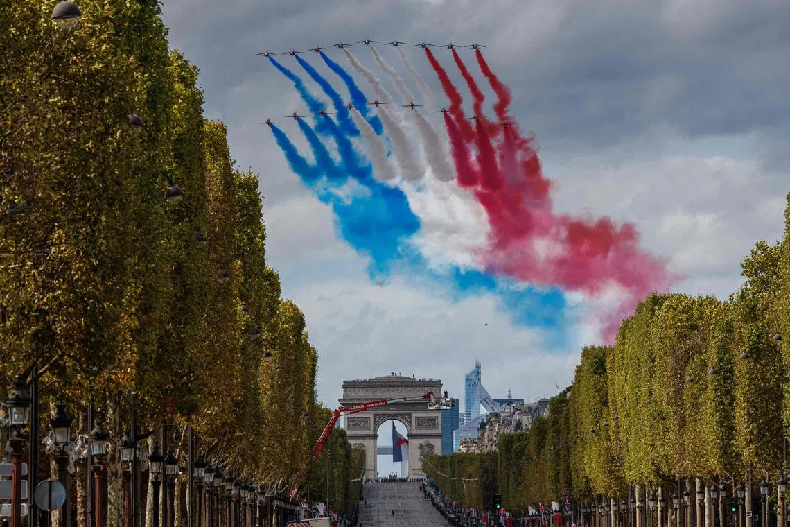French Air Force elite acrobatic flying team "Patrouille de France" (PAF) and the British Royal Air Force's (RAF) aerobatic team the "Red Arrows" perform a fly past during an official welcoming ceremony for Britain's King Charles III and Britain's Queen Camilla over The Arc de Triomphe on The Champs-Elysees Avenue in Paris on September 20.