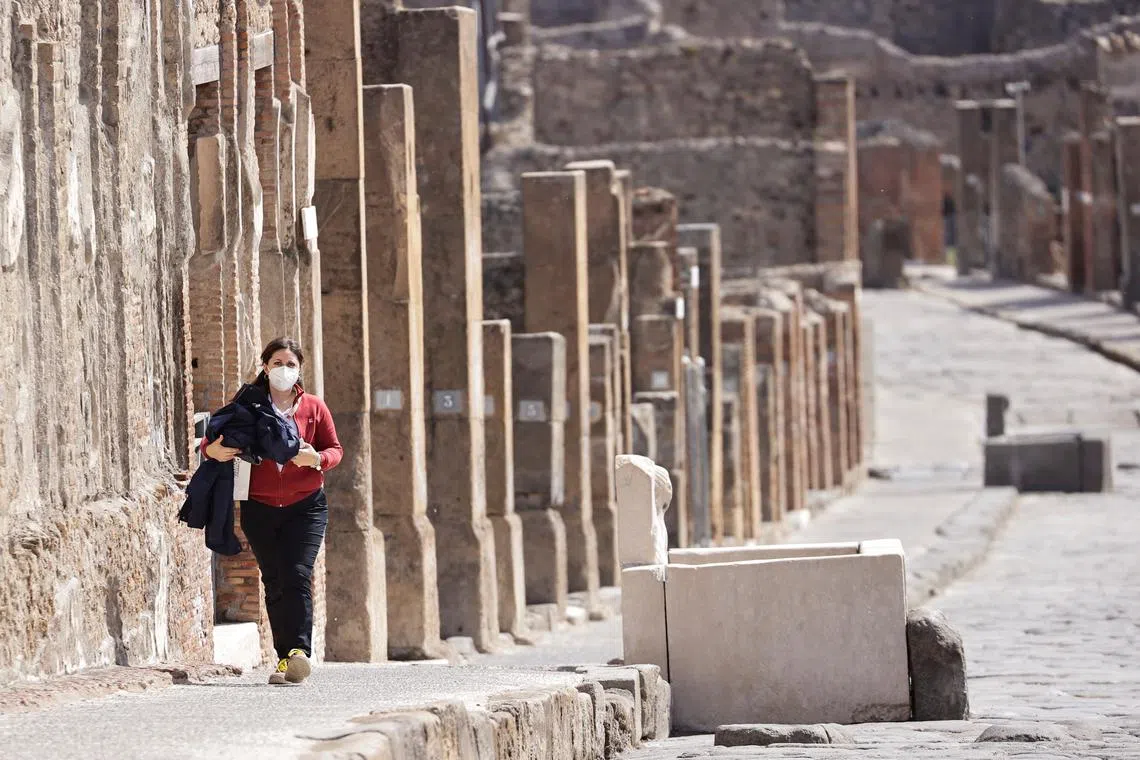 A tourist visits the archaeological site of the ancient Roman city of Pompeii, as it reopens to the public after much of the country became a \"yellow zone\", loosening coronavirus disease (COVID-19) restrictions, in Pompeii, Italy, April 27, 2021. REUTERS/Ciro De Luca/ File Photo