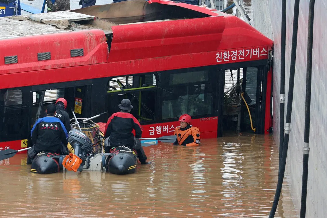 A bus is brought out of a flooded underground tunnel after flood water submerged 15 vehicles in the central town of Osong, South Korea, 16 July. Seven people are confirmed to have been killed so far in the tunnel.  