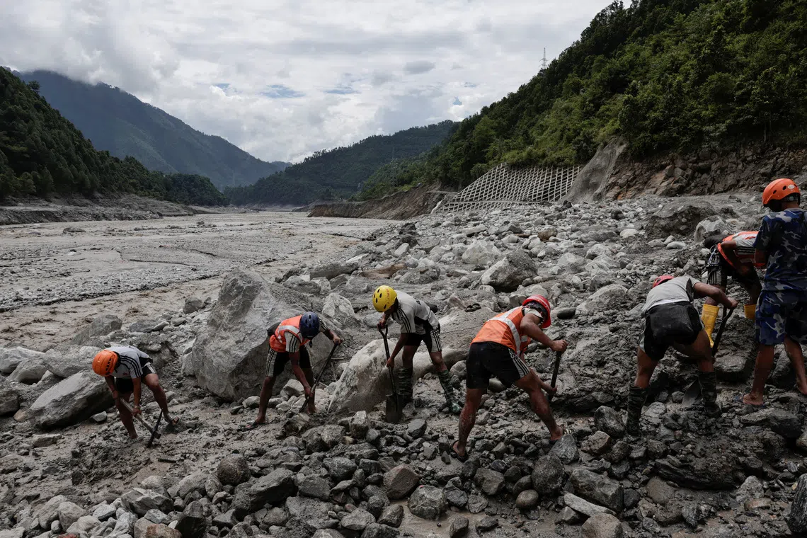 A rescue team works to clear the path towards the tunnel at Upper Trishuli 3B Hydropower Station.