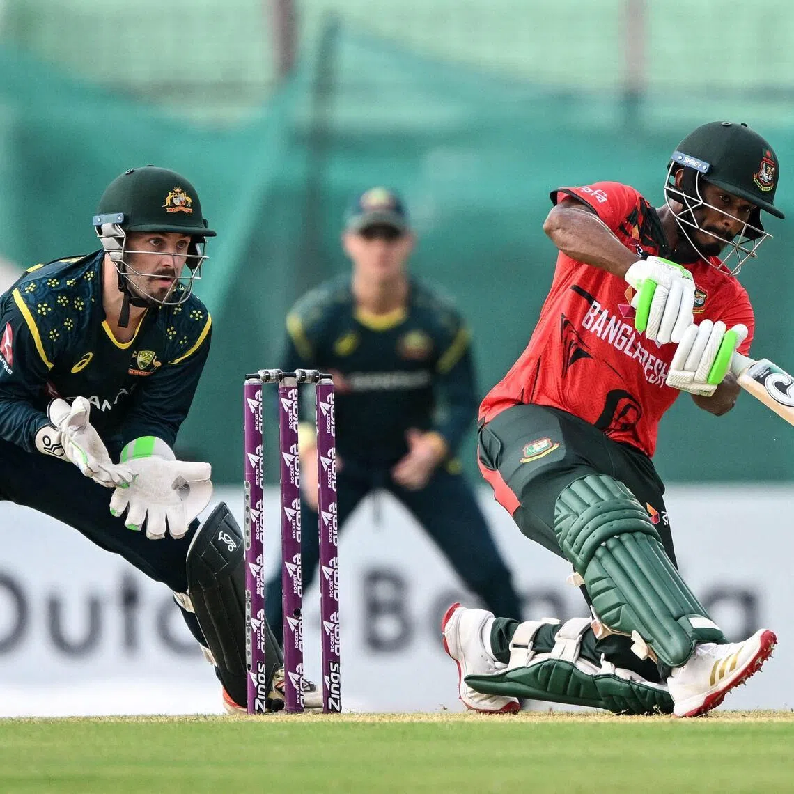 Bangladesh's Tanzid Hasan (R) plays a shot as Australia's wicketkeeper Josh Inglis looks on during the second Twenty20 (T20) international cricket match between Bangladesh and Australia at the Bir Sreshtho Flight Lieutenant Matiur Rahman Stadium in Chattogram on June 19, 2026. (Photo by AFP)