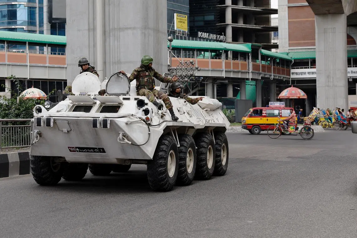FILE PHOTO: Members of Bangladesh Army gesture as they patrol in an armoured vehicle on the second-day of curfew, as violence erupted in parts of the country after protests by students against government job quotas, in Dhaka, Bangladesh, July 21, 2024. REUTERS/Mohammad Ponir Hossain/File Photo