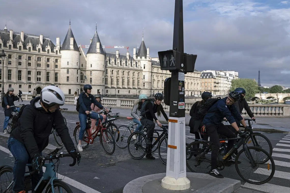 Cyclists waiting for a green light on a bridge over the Seine in Paris on June 17.  The French capital has seen an explosion in bikes and cycling lanes in recent years.