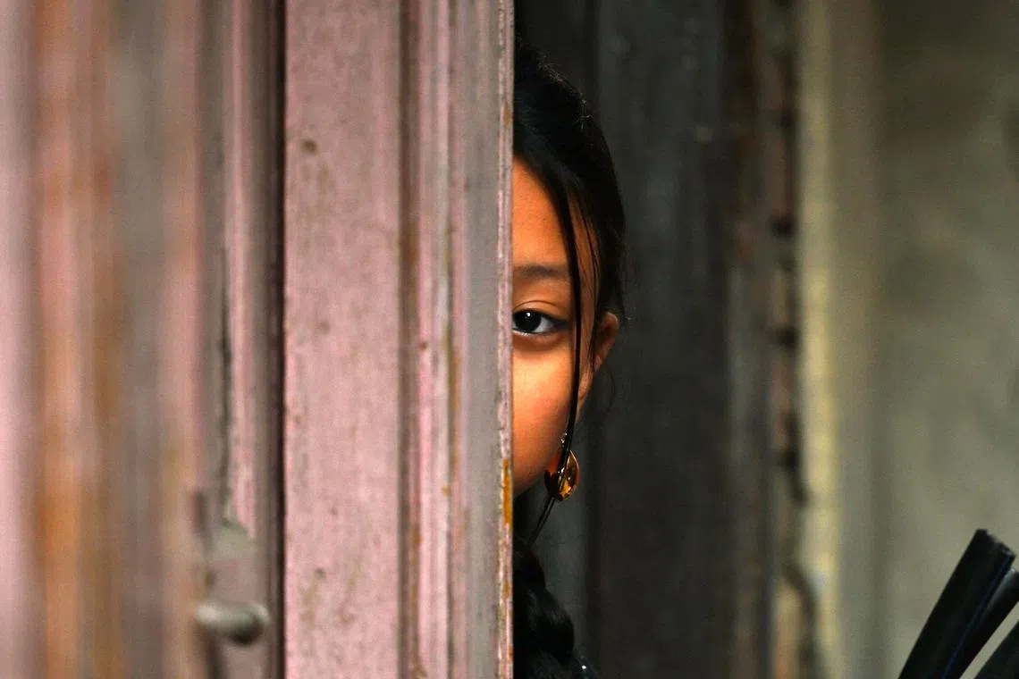 TOPSHOT - A girl watches the members of Nepali ethnic Newar community participating in 'Jyapu Day' celebrations that marks the end of the harvest season, in Kathmandu on December 26, 2023. (Photo by Prakash MATHEMA / AFP)