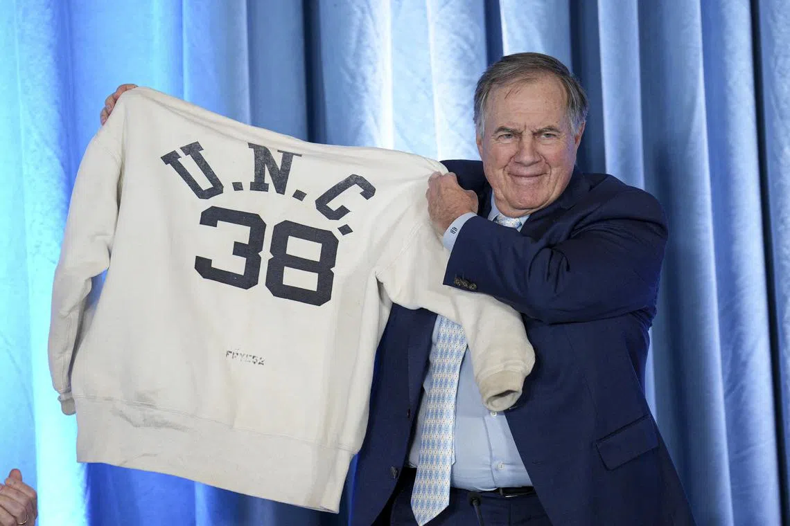 Dec 12, 2024; Chapel Hill, NC, USA;   North Carolina Tar Heels new head coach Bill Belichick holds up the sweatshirt worn by his father when he was an assistant coach at New North Carolina Tar Heels new at Loudermilk Center for Excellence. Mandatory Credit: Jim Dedmon-Imagn Images