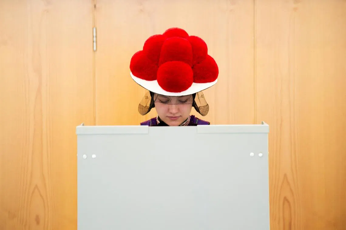 A woman wears the traditional Black Forest costume as she votes in Gutach, Black Forest, Germany, February 23, 2025. REUTERS/Steffen Schmidt