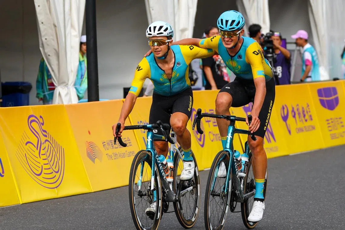 Kazakhstan's Alexey Lutsenko and Yevgeniy Fedorov pass the finish line together during the men"s road race at the Asian Games.
