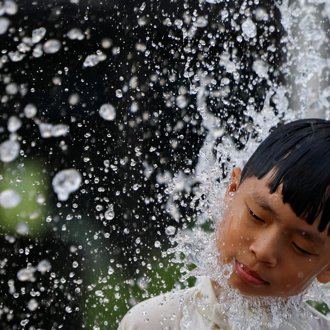 A boy cools off in a fountain during a heatwave in Seoul on July 31.