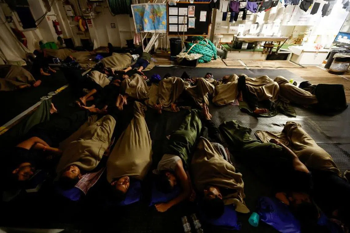 FILE PHOTO: Migrants sleep on the deck of the Geo Barents migrant rescue ship, operated by Medecins Sans Frontieres (Doctors Without Borders), as it makes its way to Italy after the rescue of 61 migrants on a wooden boat in international waters off the coast of Libya in the central Mediterranean Sea, September 29, 2023. REUTERS/Darrin Zammit Lupi/File Photo
