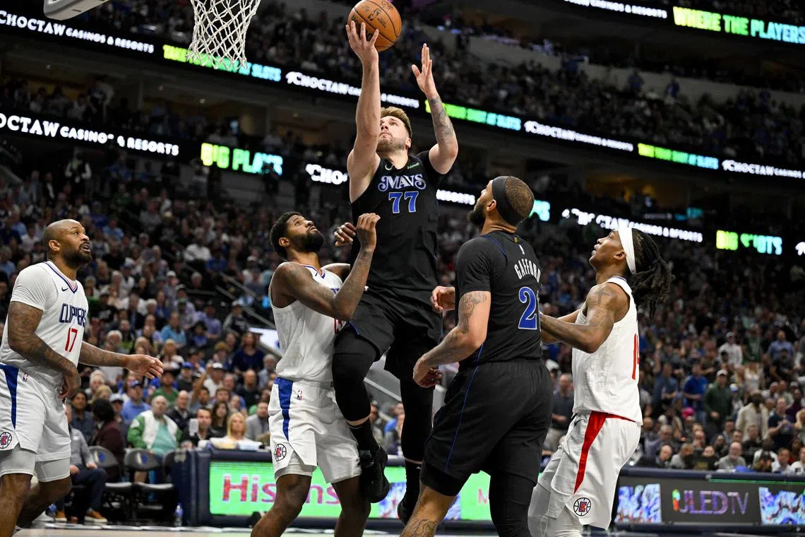 Dallas Mavericks guard Luka Doncic shoots the ball over LA Clippers forward Paul George and guard Terance Mann during the third quarter in Game 6 of their NBA Western Conference first-round play-offs.