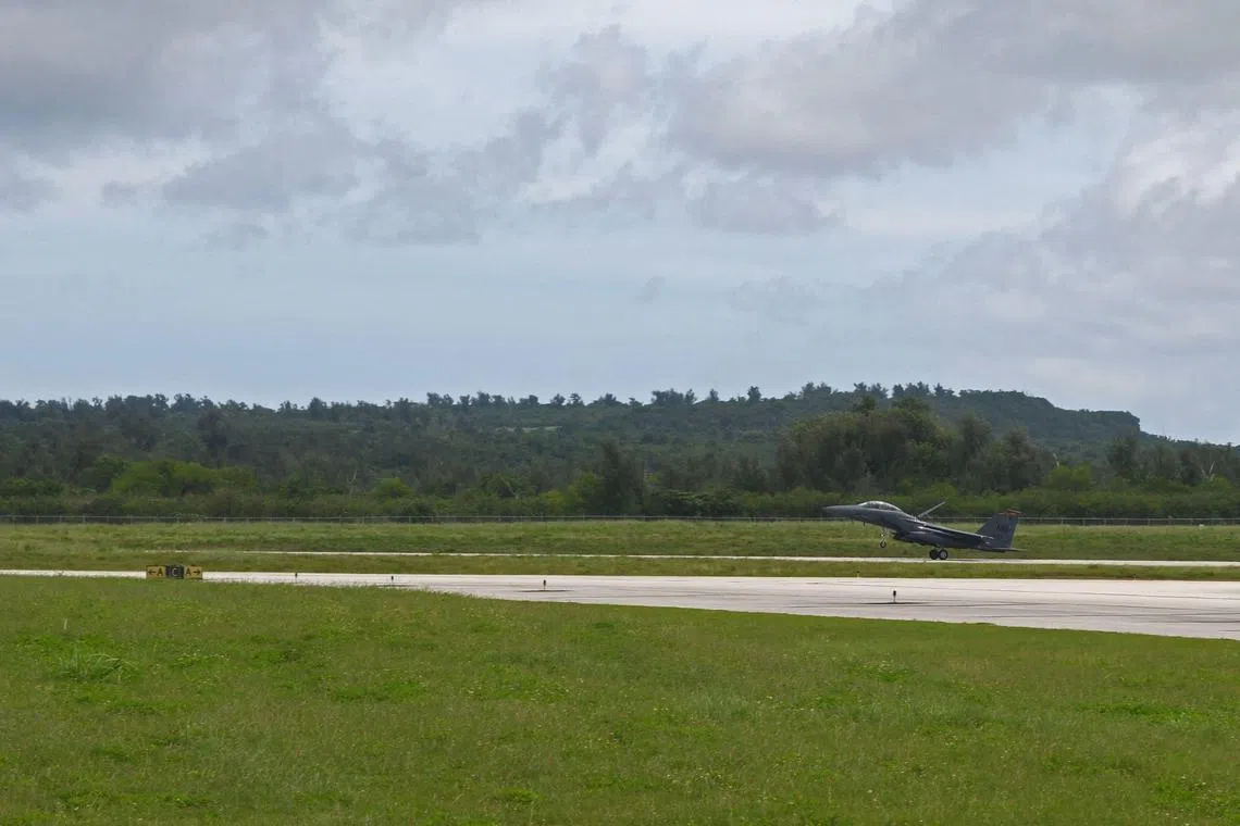 This US Air Force handout image shows an F-15E Strike Eagle from Mountain Home Air Force Base, Idaho, landing on the runway at the Tinian International Airport, Tinian, July 27, 2021. In the middle of the Pacific ocean, an abandoned US airfield once key to dropping the nuclear bomb on Japan -- and nearly lost to history amid encroaching forest -- is being revived. But as the Americans hack away at the jungle overgrowth at Tinian island airfield and other old, World War II-era bases across the region, it won't be with Japan on their mind. Rather, it's Beijing's growing influence in the Pacific that is spurring the recovery of a slew of abandoned runways on the 40 square-mile speck of land that makes up Tinian, part of the US overseas territory of the Northern Mariana Islands. "Rehabilitation of World War II-era airfields has provided Pacific Air Forces (PACAF) a rapidly executable avenue to enhance infrastructure in the region," a spokesperson told AFP. (Photo by Benjamin SUTTON / US AIR FORCE / AFP) / RESTRICTED TO EDITORIAL USE - MANDATORY CREDIT "AFP PHOTO / US AIR FORCE / Technical sergeant Benjamin Sutton " - NO MARKETING - NO ADVERTISING CAMPAIGNS - DISTRIBUTED AS A SERVICE TO CLIENTS / To go with AFP story by Ulysse BELLIER: "China tensions rising, US revives WWII-era Pacific airfield"