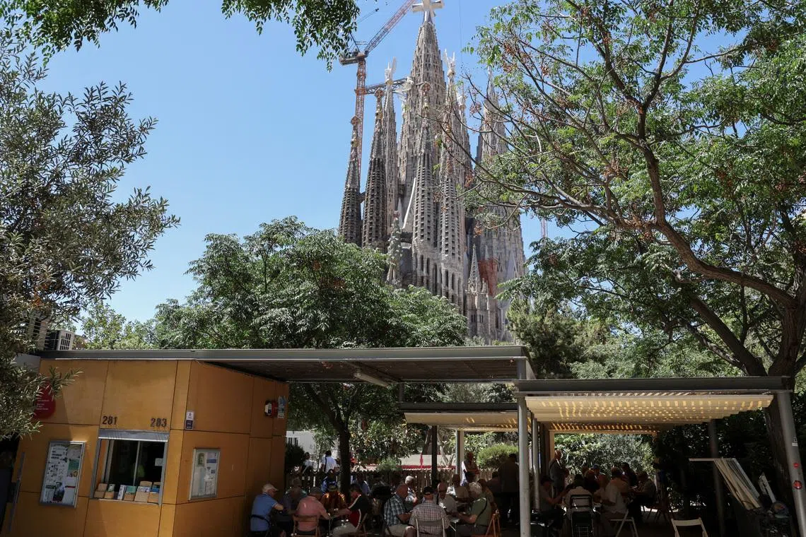 Neighbours play cards and dominoes in front of the Sagrada Familia basilica, designed by Catalan architect Antoni Gaudi, ahead of Pope Leo XIV's visit to Barcelona, ​​Spain, June 3, 2026. REUTERS/Nacho Doce