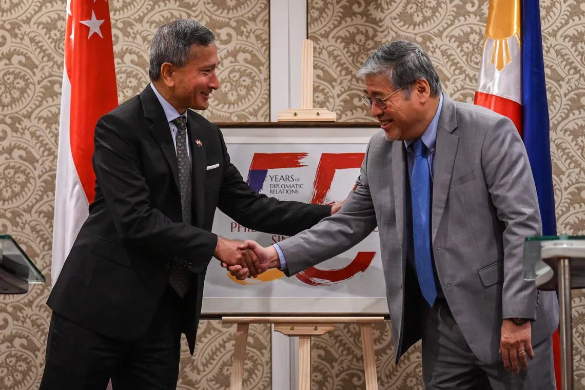 Singapore's Foreign Minister Vivian Balakrishnan (left) and Philippine Foreign Secretary Enrique Manalo shake hands during a press conference in Manila.