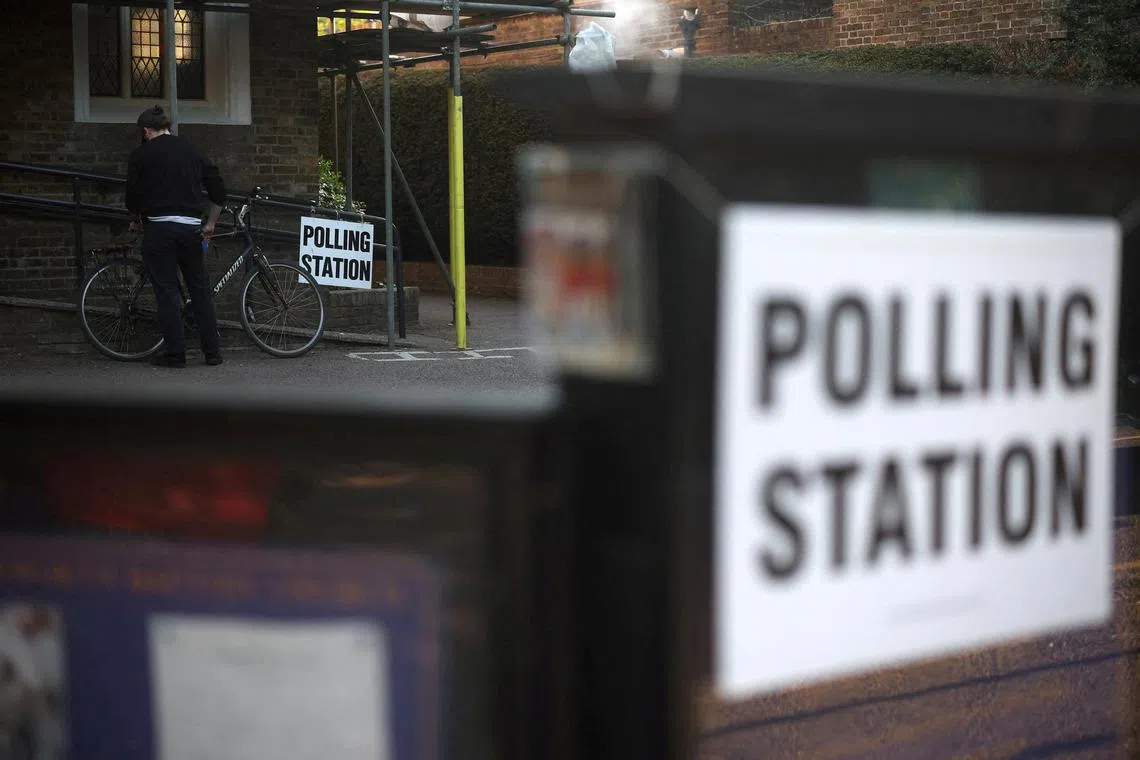 FILE PHOTO: A man unlocks his bicycle after voting at a polling station in Rickmansworth, Britain, May 1, 2025. REUTERS/Suzanne Plunkett/File Photo
