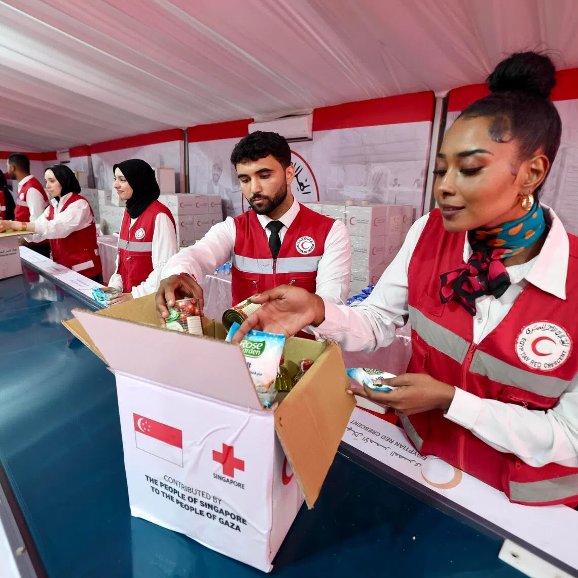 Egyptian Red Crescent volunteers in Cairo packing aid from the Singapore Red Cross to deliver to Palestinians in September. 