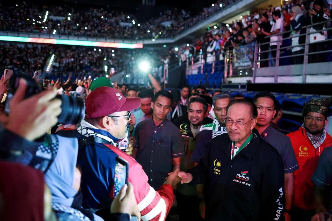 Malaysian Prime Minister Anwar Ibrahim greets attendees at a pro-Palestine rally in Kuala Lumpur, Malaysia.
