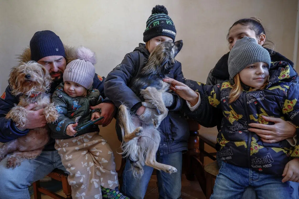 The Davydenko family (from left to right): Denys, 40, Yuliia, 40, and their children Maksym, 11, Tymofiy, 6, and Stephanie, 2 pose for a picture wearing winter clothes in the kitchen of their apartment, which has no heating or hot water and experiences frequent power outages amid Russia's attack on Ukraine, in Kyiv, Ukraine, February 1, 2026. Waves of Russian attacks over the past four months left hundreds of thousands without electricity and water, making this the most devastating winter since the war started; and so the Davydenko family made the choice to stay at the family-owned Piggy Cafe Kyiv - with power supplied by a generator and heating. \"Maksym likes it,\" Denys joked about their new reality. \"He actually says that at home we have to do household chores. Now there's no dish-washing, cleaning, walking the dogs. So he is happy about that.\" REUTERS/Alina Smutko