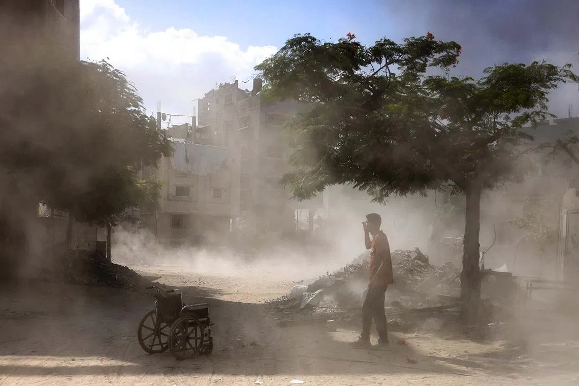 A Palestinian man standing next to an empty wheelchair following an explosion in the Saftawi neighbourhood in the northern Gaza Strip on Aug 25, 2025, amid the ongoing war between Israel and the Palestinian militant group Hamas.