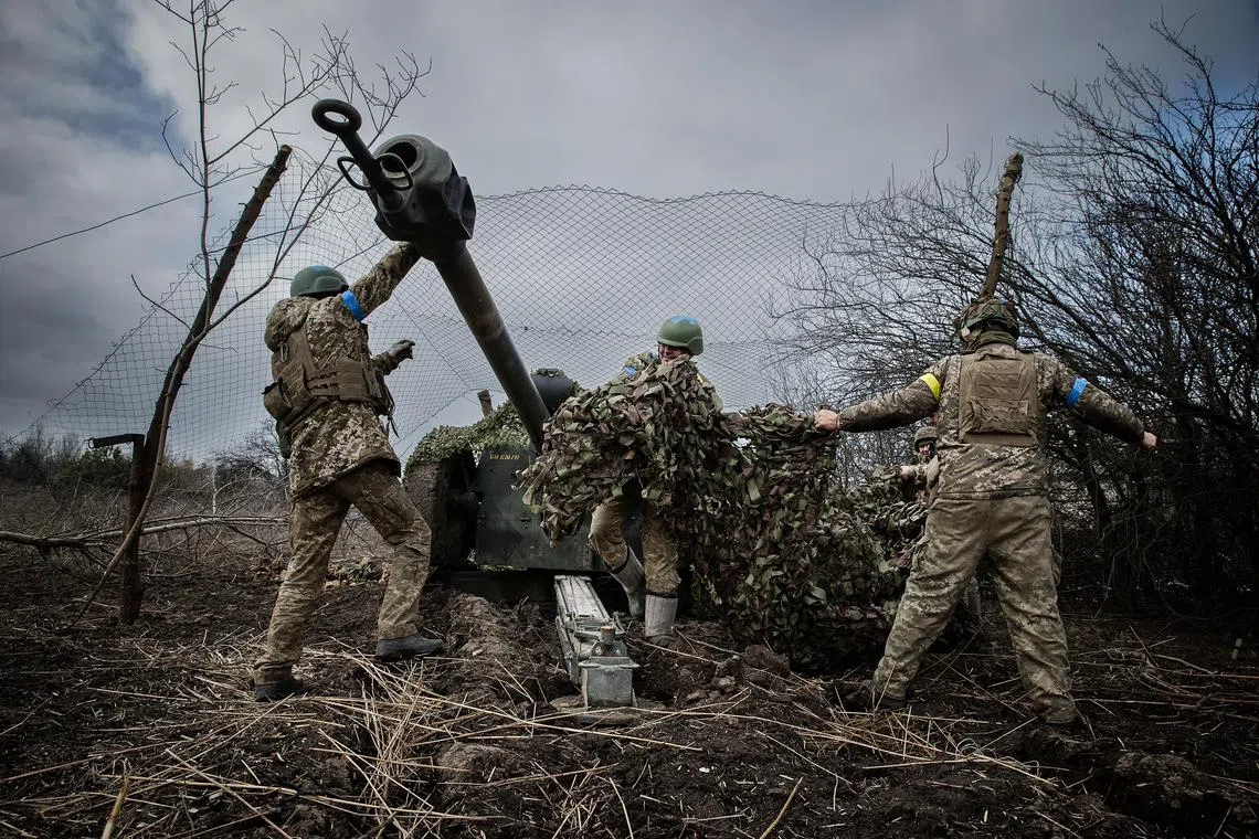 Ukrainian soldiers prepare to fire a howitzer at Russian forces near Maryinka, in the Donetsk region of eastern Ukraine.