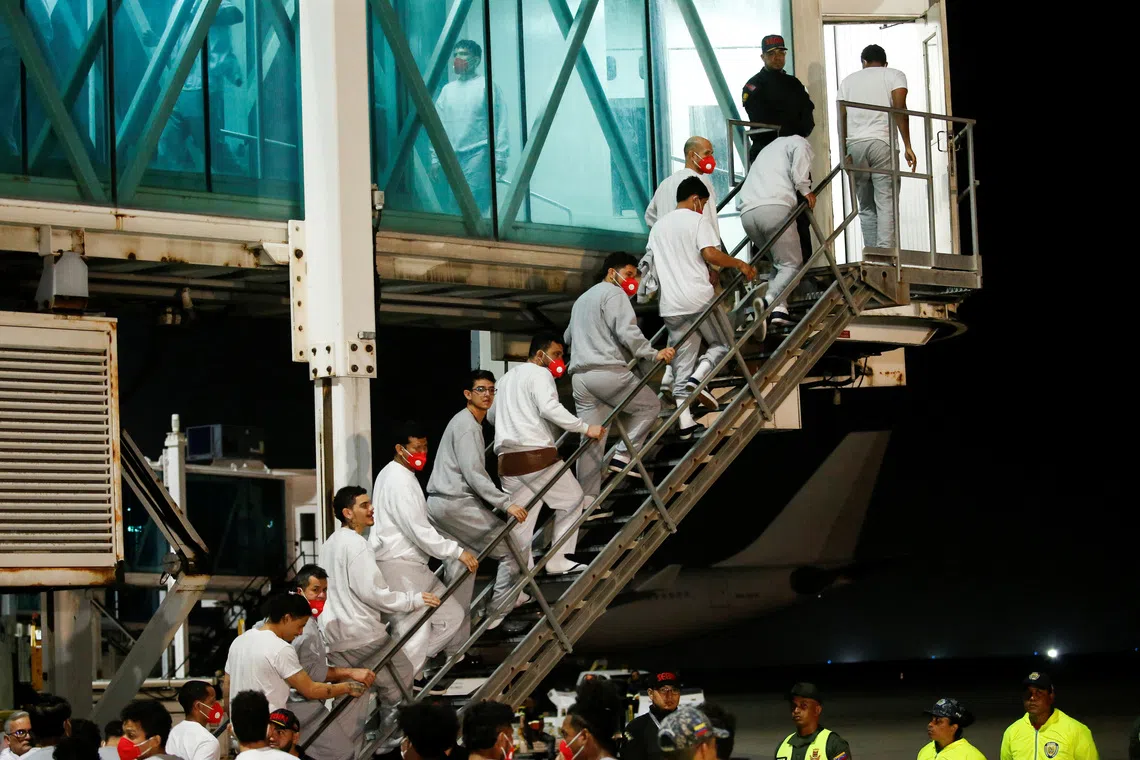 Venezuelan migrants flown from Guantanamo Bay via Honduras, walk up a ladder after arriving on a deportation flight at Simon Bolivar International Airport in Maiquetia, La Guaira State, Venezuela, February 20, 2025. REUTERS/Leonardo Fernandez Viloria