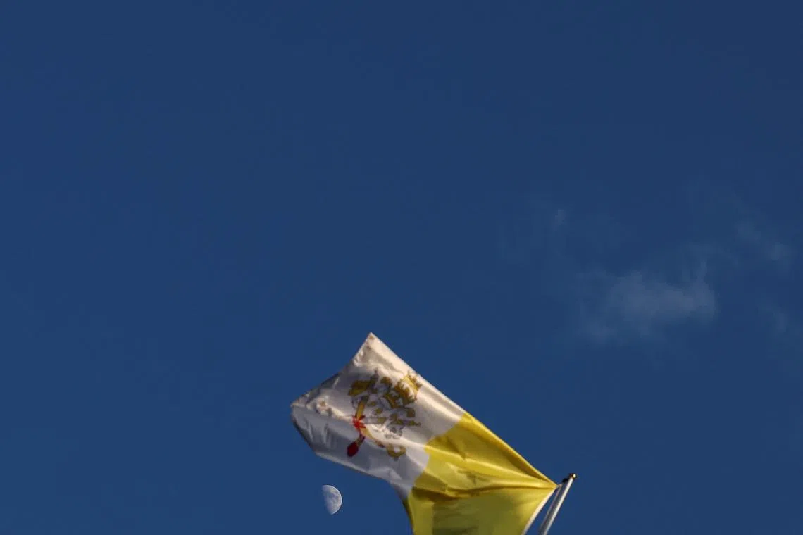 The moon is seen behind the Vatican's flag, ahead of the conclave to elect the next pope in Rome, Italy, on May 5, 2025. 