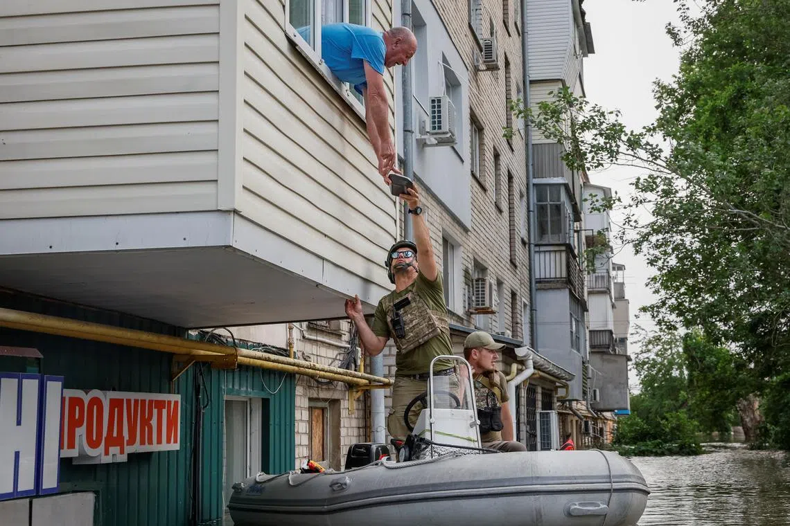 Serhii, a local resident, receives humanitarian aid, after the Nova Kakhovka dam breached, amid Russia's attack on Ukraine, in Kherson, Ukraine, June 7, 2023. 