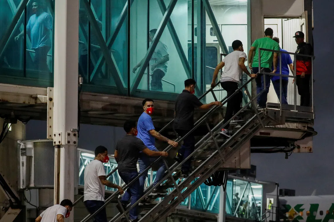 Venezuelan migrants who had been detained in El Salvador walk up stairs to the terminal after disembarking from a plane at Simon Bolivar International Airport in Maiquetia, Venezuela, July 18, 2025. REUTERS/Leonardo Fernandez Viloria