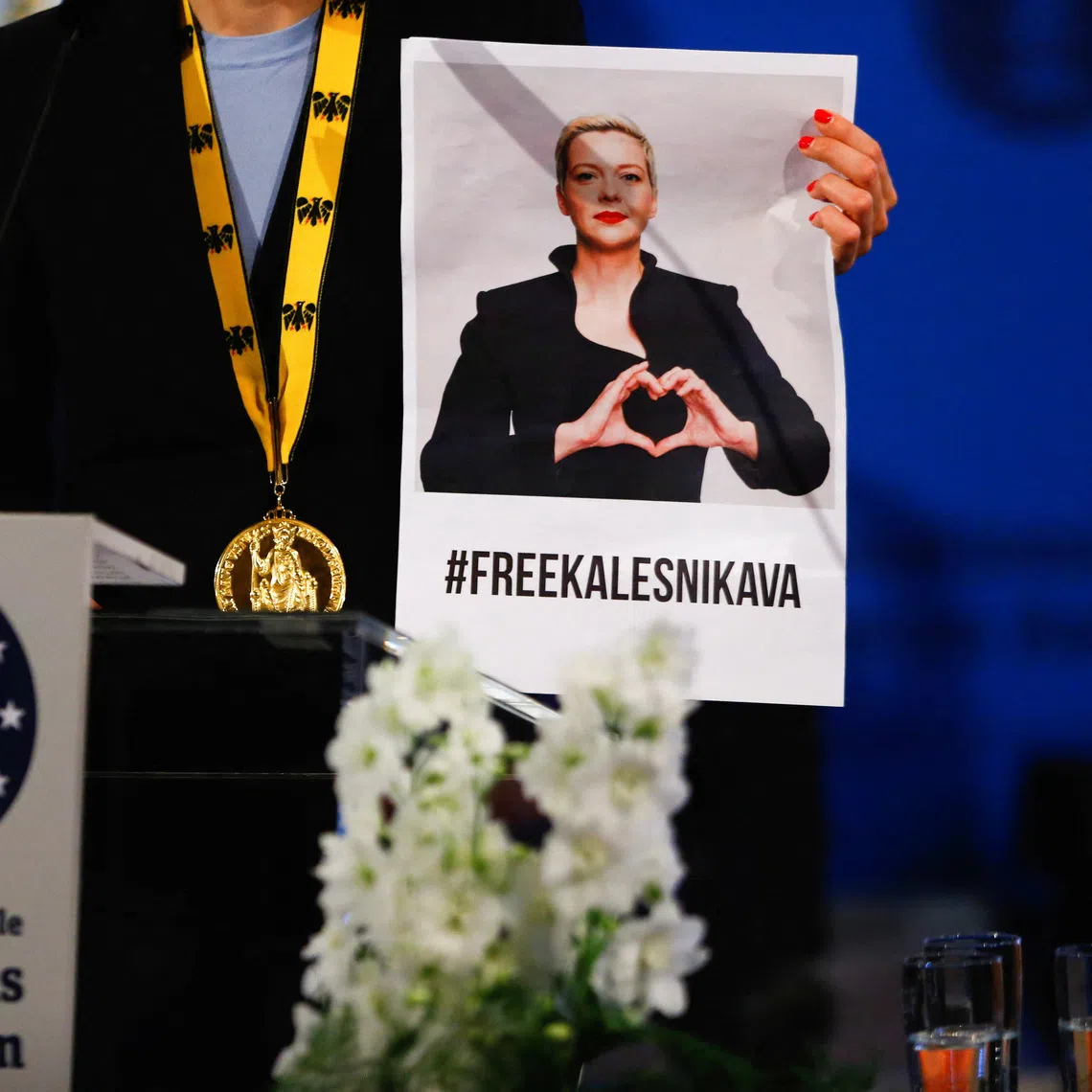 FILE PHOTO: Tatsiana Khomich holds up a picture of her detained sister Maria Kalesnikava as she gives a speech after accepting the Charlemagne Prize on her behalf, during a ceremony in Aachen, Germany, May 26, 2022. REUTERS/Thilo Schmuelgen/File Photo