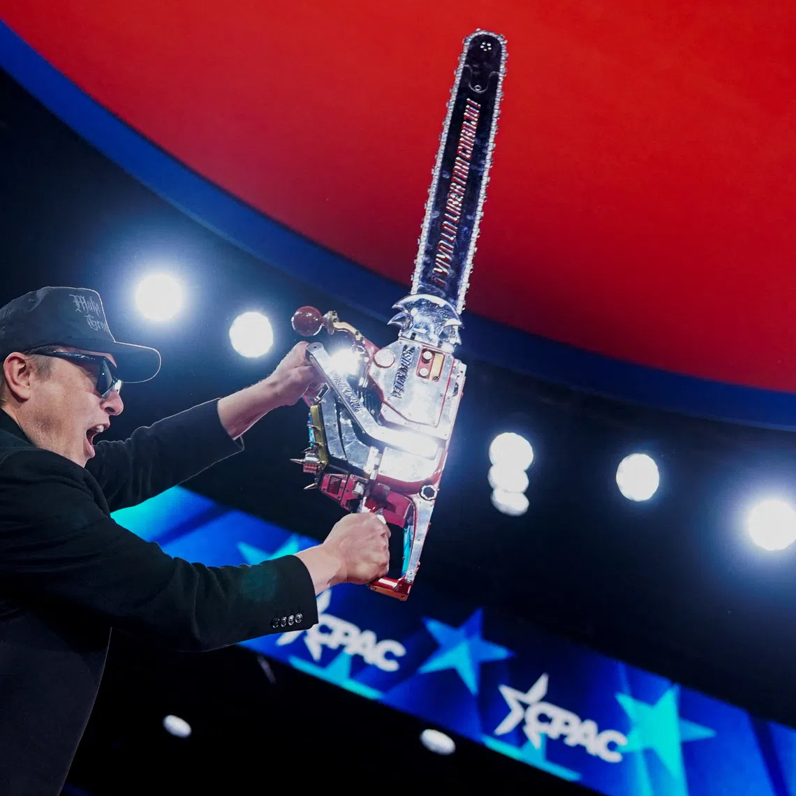 Elon Musk holds up a chainsaw onstage during the Conservative Political Action Conference (CPAC) in National Harbor, Maryland, U.S., February 20, 2025. REUTERS/Nathan Howard/File Photo