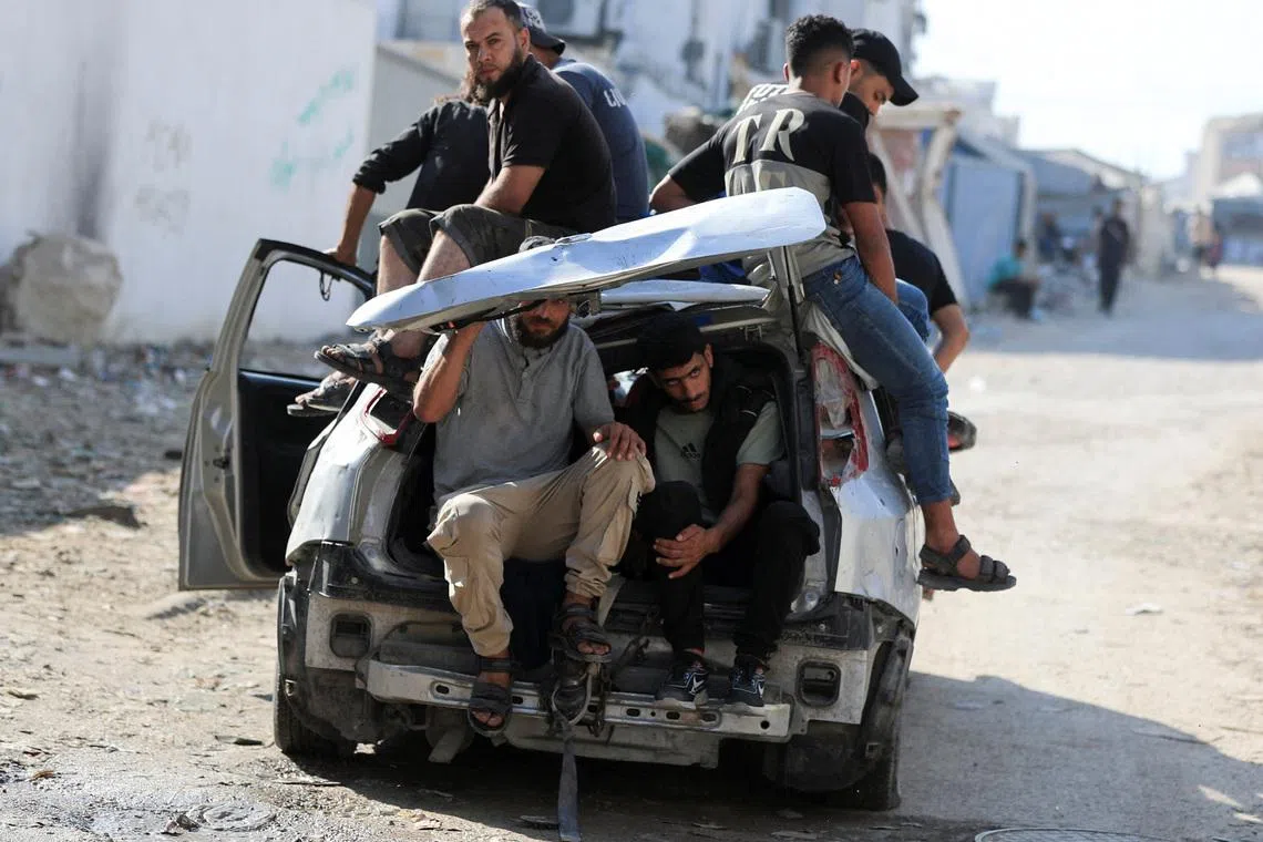 Mourners sit inside and atop a damaged car during the funeral of three Palestinians, who were killed in an Israeli strike, according to medics, in Gaza City, July 16, 2026. REUTERS/Dawoud Abu Alkas