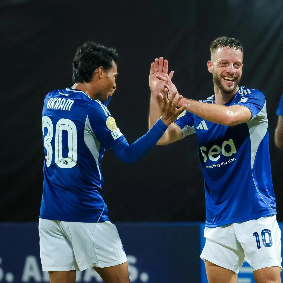 Lion City Sailors attacker Bart Ramselaar (centre) celebrates with Akram Azman (left) and Tsiy-William Ndenge after scoring in a 5-1 Singapore Premier League win against Hougang United at Bishan Stadium.