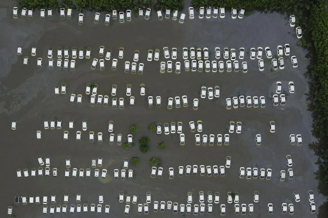 An aerial picture shows a parking area flooded in Suthiyana, Greater Noida on July 26, 2023, after the Hindon River, a tributary of the Yamuna River, overflew due to an increase in water discharge following monsoon rains. 