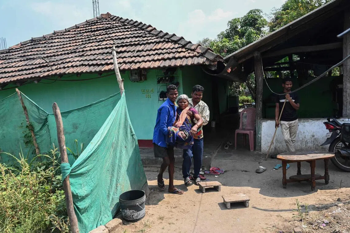 Ms Tama Jogi, a tribal resident who lost her legs in a landmine explosion, is helped by family members at the Awapalli village in Chhattisgarh’s Bijapur district on April 1. 