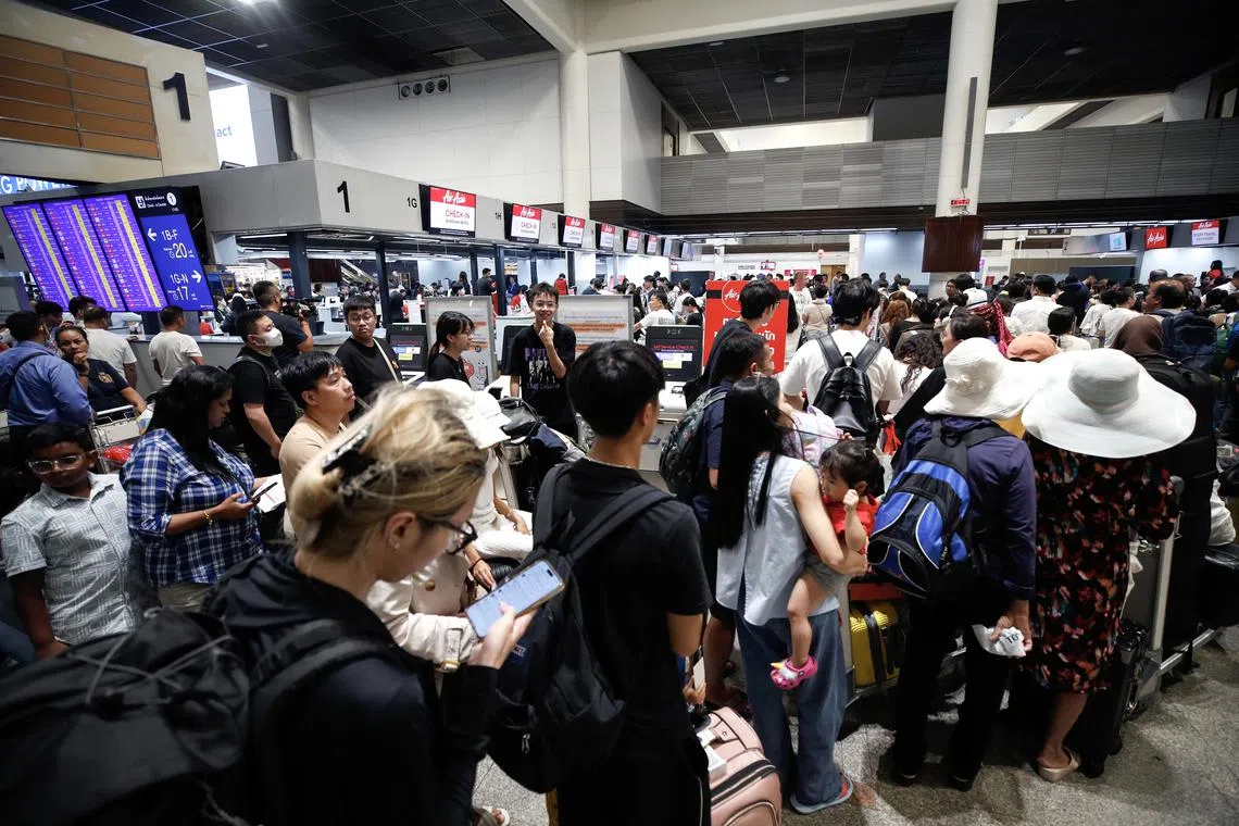 Travelers queue up to check in for AirAsia airline flights during a global technical outage at Don Mueang International Airport in Bangkok, Thailand, on July 19, 2024.