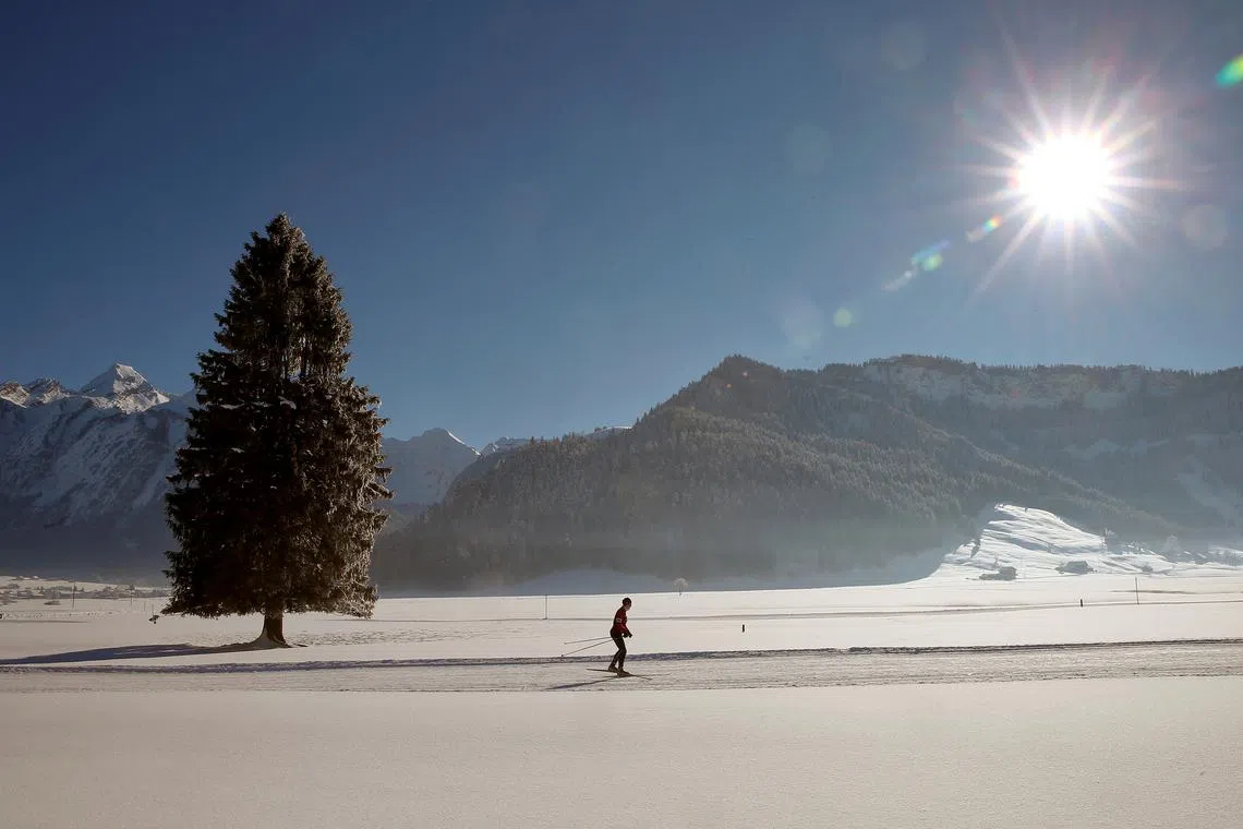 FILE PHOTO: A cross-country skier is seen in the snow-covered landscape during sunny winter weather near Unteriberg, Switzerland January 20, 2017.  REUTERS/Arnd Wiegmann