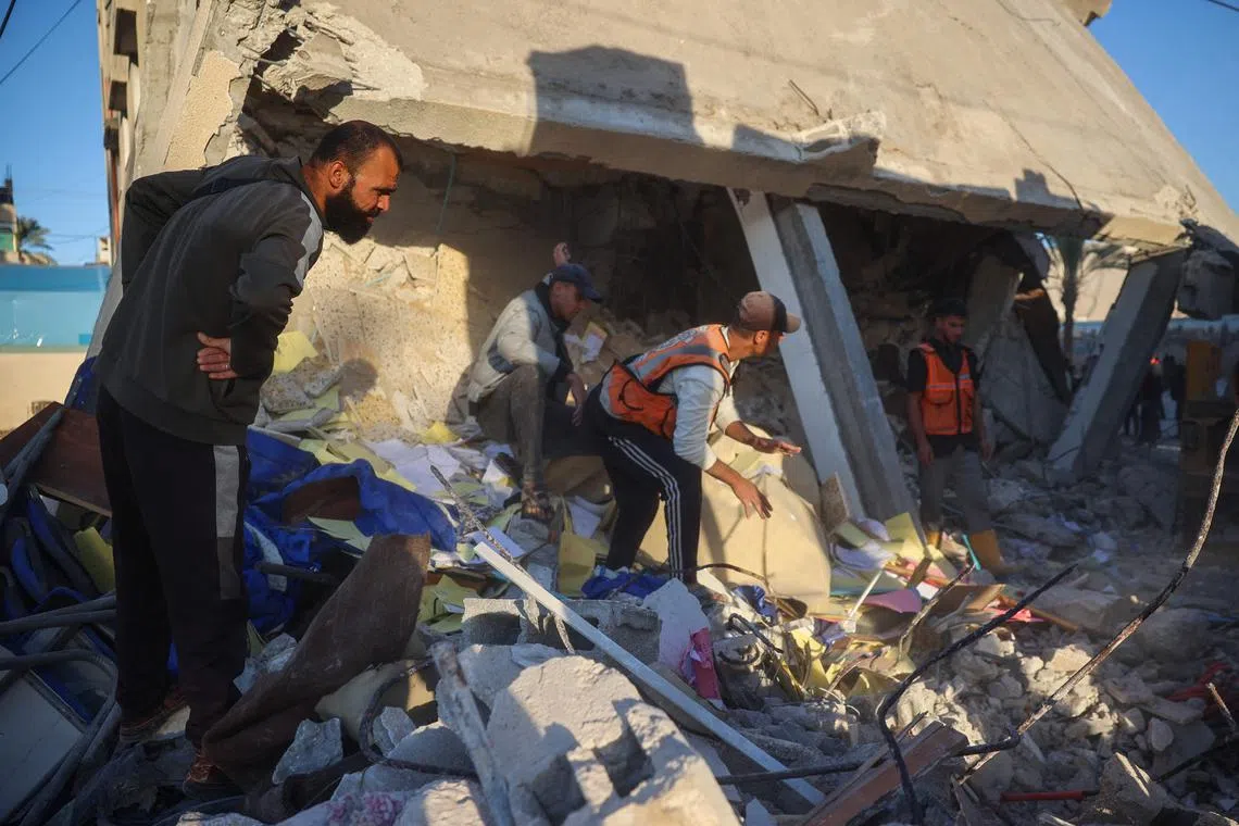 Rescuers searching the rubble for casualties, following an Israeli air strike on a building in Deir Al-Balah, in the central Gaza Strip, on Dec 14.