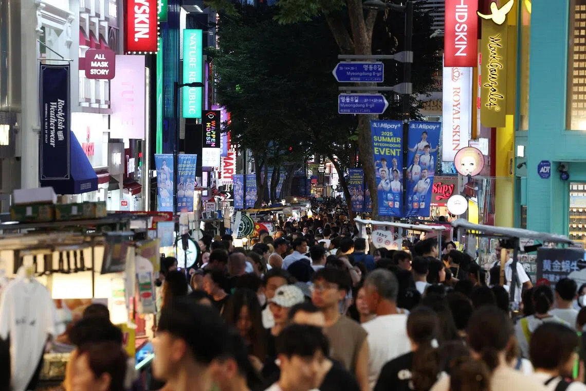 People walk at Myeongdong shopping district in Seoul, South Korea, on Aug 5.