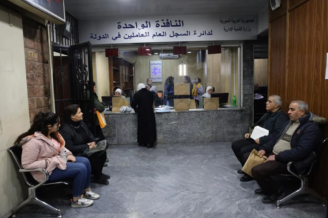 People wait at a government building in Damascus suburb, Syria January 8, 2025.REUTERS/Khalil Ashawi