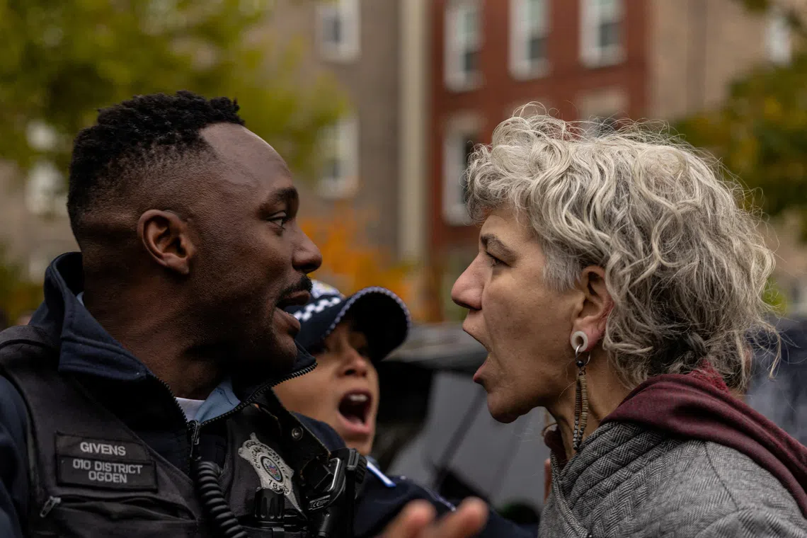 A resident shouts at a Chicago Police officer after an immigration raid conducted by federal law enforcement agents at the Little Village neighborhood, in Chicago, Illinois, U.S., November 8, 2025. REUTERS/Carlos Barria