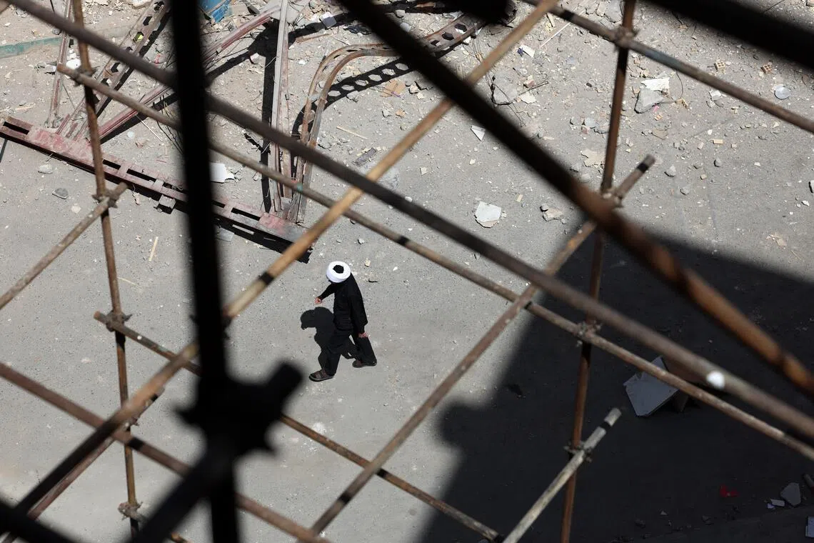 An Iranian cleric walks around the scene of residential buildings which were destroyed by US-Israeli airstrikes at the Shahid Broujerdi residential complex in southern Tehran, Iran, on April 14, 2026.