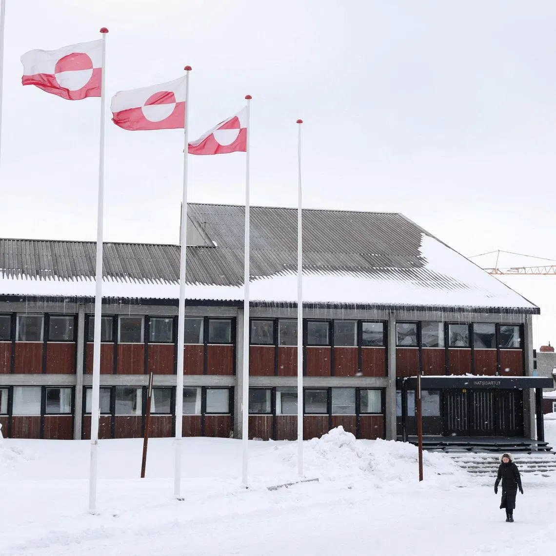 FILE PHOTO: A woman walks past Greenland's parliament Inatsisartut in Nuuk, Greenland, March 28, 2025. REUTERS/Leonhard Foeger/File Photo