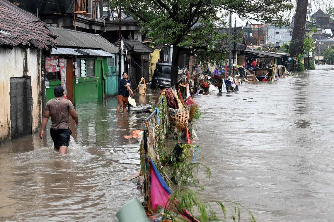 Residents wading through flood waters after heavy rain in Bali on Sept 10. 