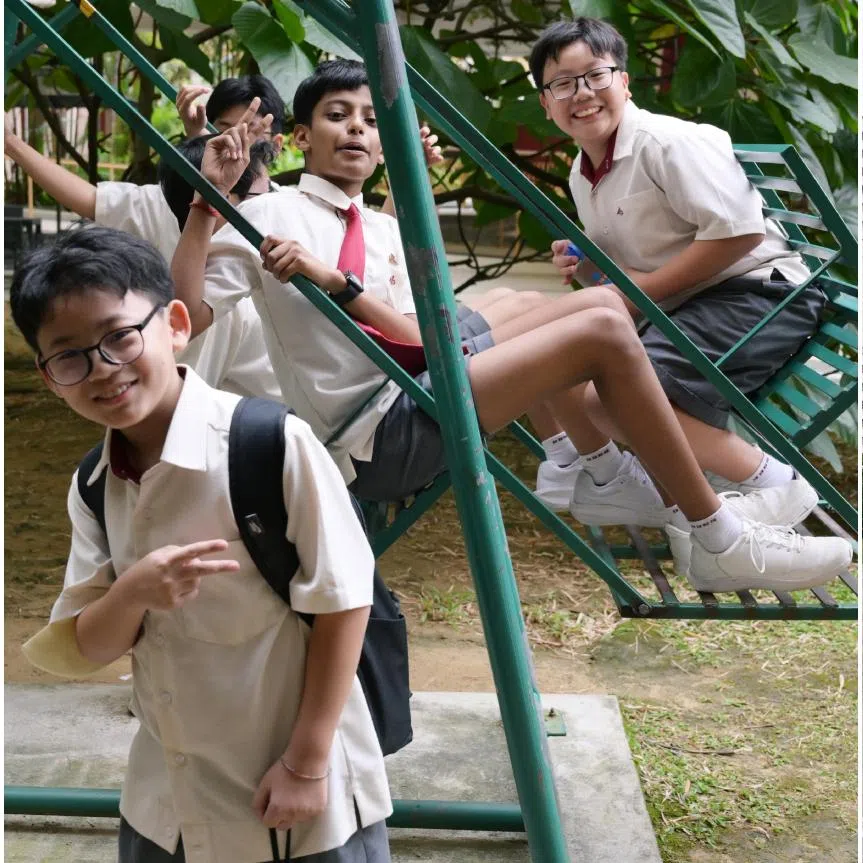 Bukit Batok Secondary School students hanging out on a swing during recess time and playing basketball during breaks.