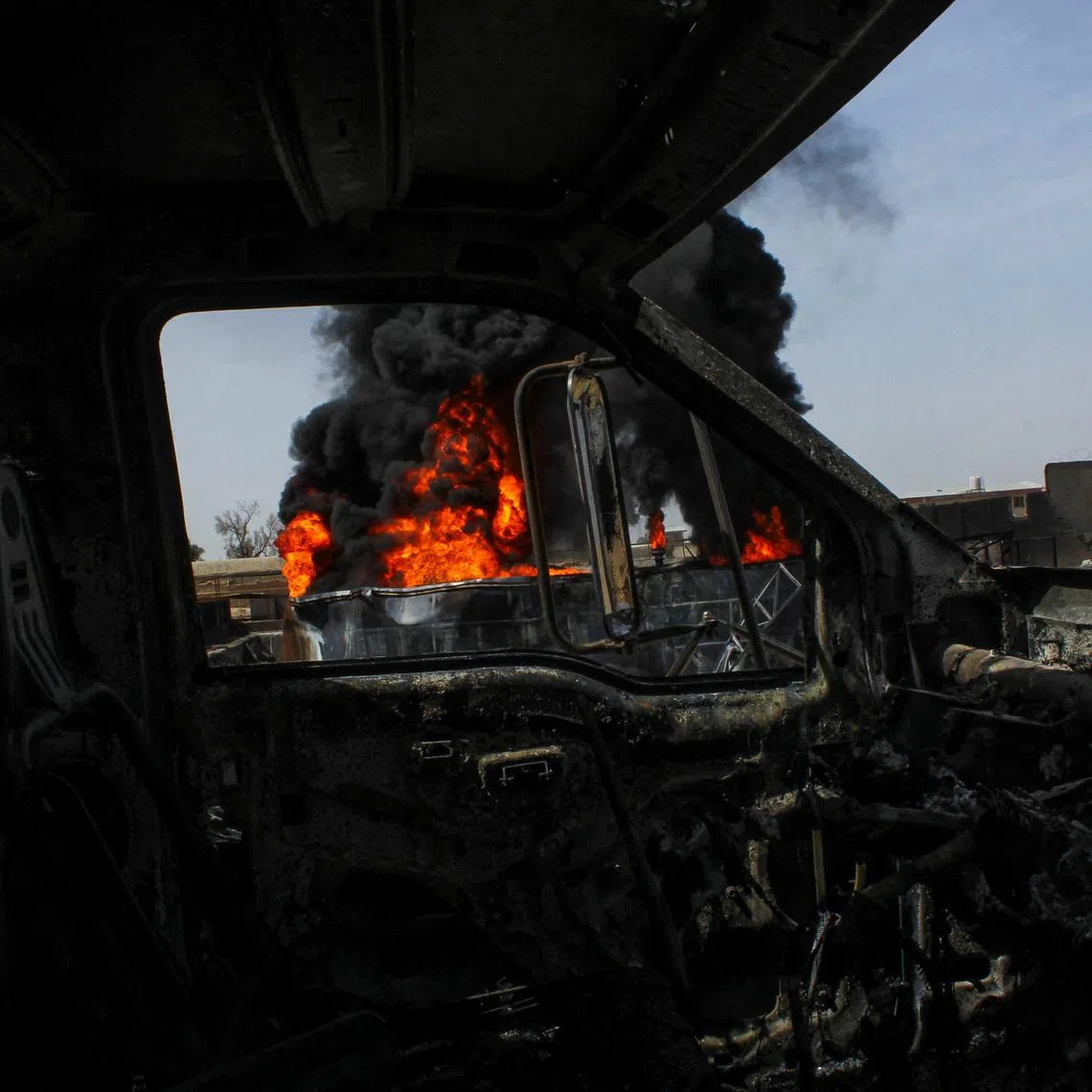 Thick black smoke is seen through a destroyed truck at the private airline Kam Air's fuel depot after a strike in what the Taliban said was a Pakistani air strike, in Kandahar, Afghanistan, March 13, 2026. REUTERS/Stringer