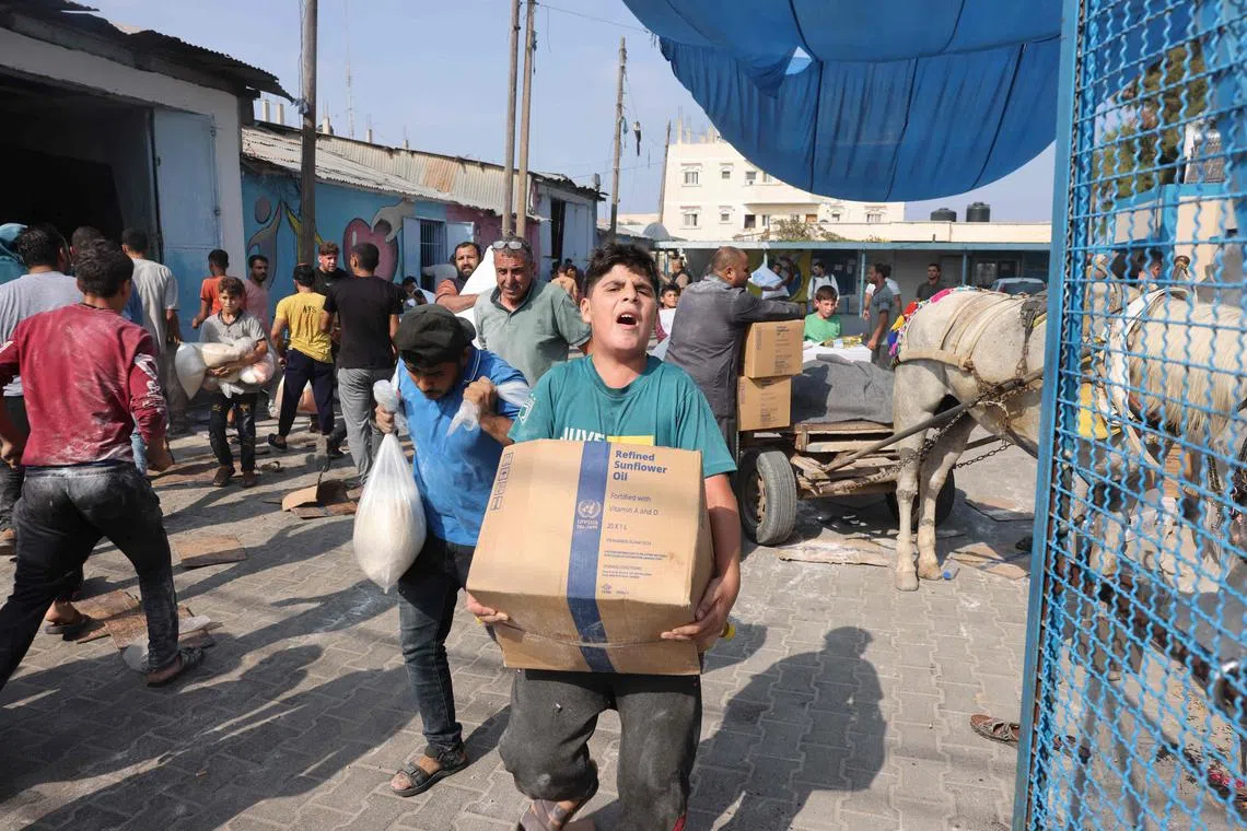 Palestinians collect food from a UN-run aid supply centre amid the ongoing battles between Israel and Hamas.