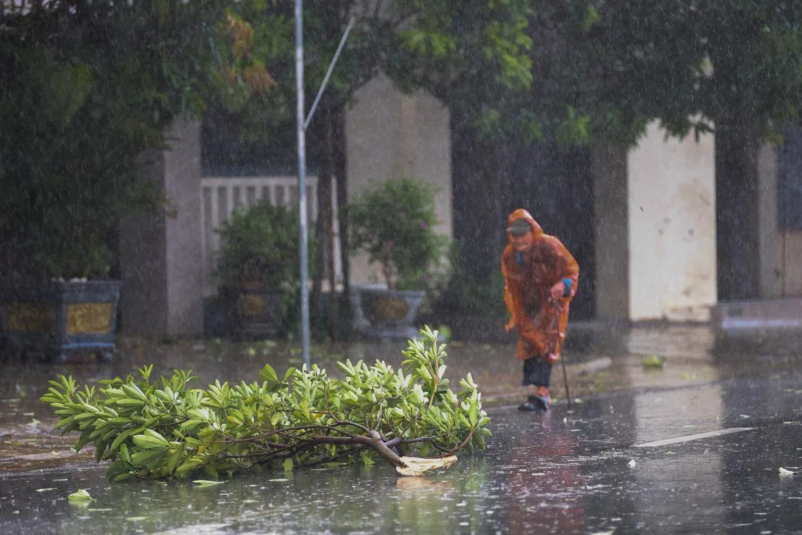 A woman walks on a street while Typhoon Kajiki approaches Nghe An province, Vietnam, August 25, 2025. REUTERS/Minh Nguyen