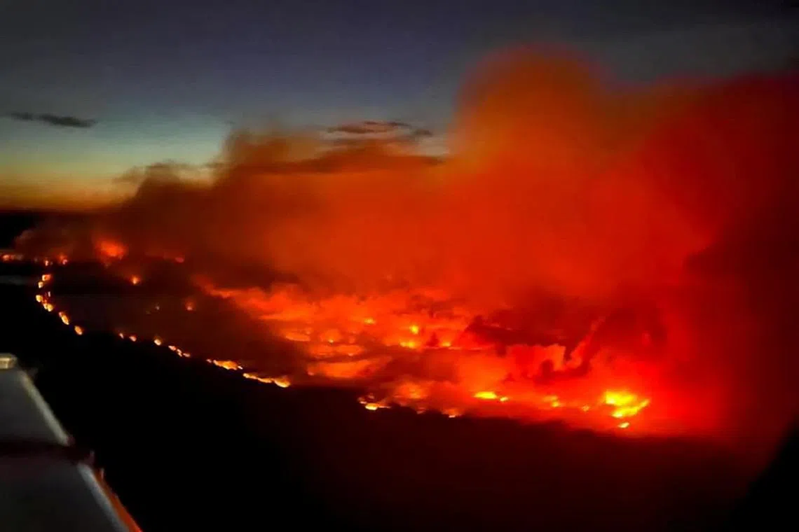 FILE PHOTO: The Parker Lake wildfire glows in an aerial photograph taken by a B.C. Emergency Health Services crew member through the window of an airplane evacuating patients from nearby Fort Nelson, British Columbia, Canada May 10, 2024. Andrei Axenov/BCEHS/Handout via REUTERS/File Photo