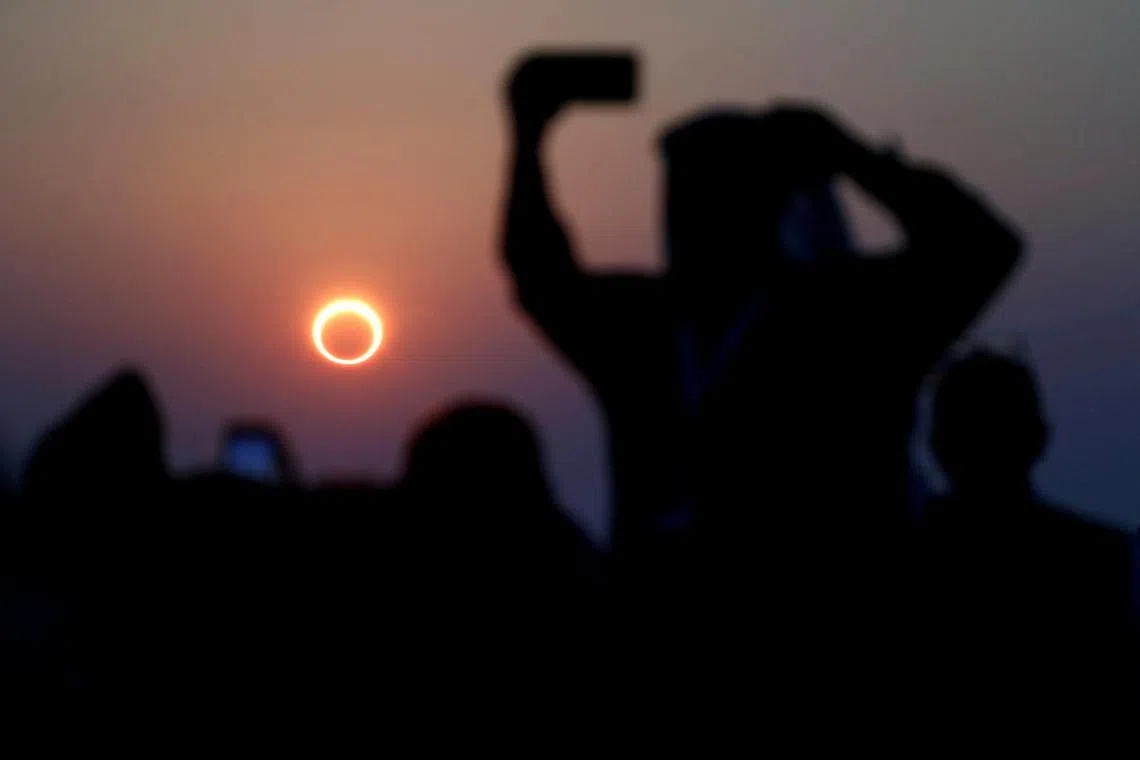 FILE PHOTO: People take photos with their smartphones as they monitor the annular solar eclipse on Jabal Arba (Four Mountains) in Hofuf, in the Eastern Province of Saudi Arabia, December 26, 2019. REUTERS/Hamad I Mohammed/File Photo