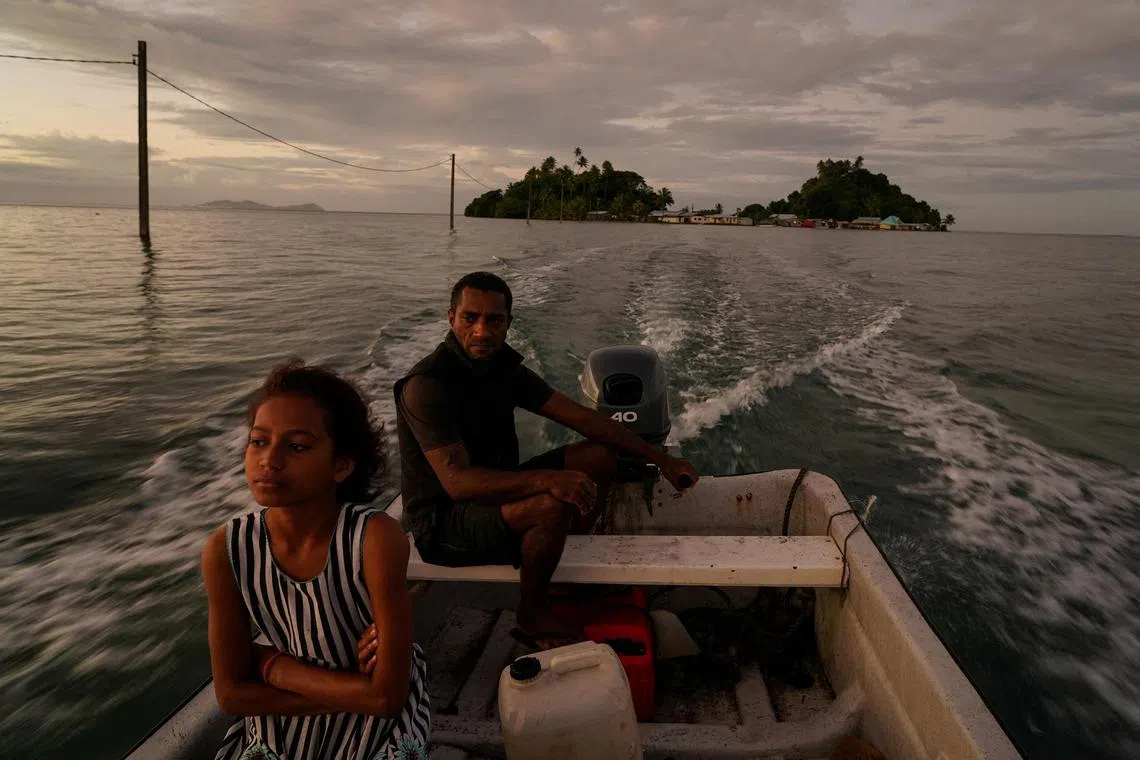 FILE PHOTO: A man drives his boat from Serua Island to the mainland at high tide,  as rising sea level force Fiji villagers to relocate to higher ground, near Serua Village, Fiji, July 14, 2022.  REUTERS/Loren Elliott/File Photo