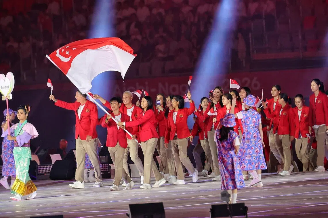 Team Singapore, led by flag bearers Brandon Ooi (left) from kayaking and Kiria Tikanah (right) from fencing, on stage for the athletes parade.